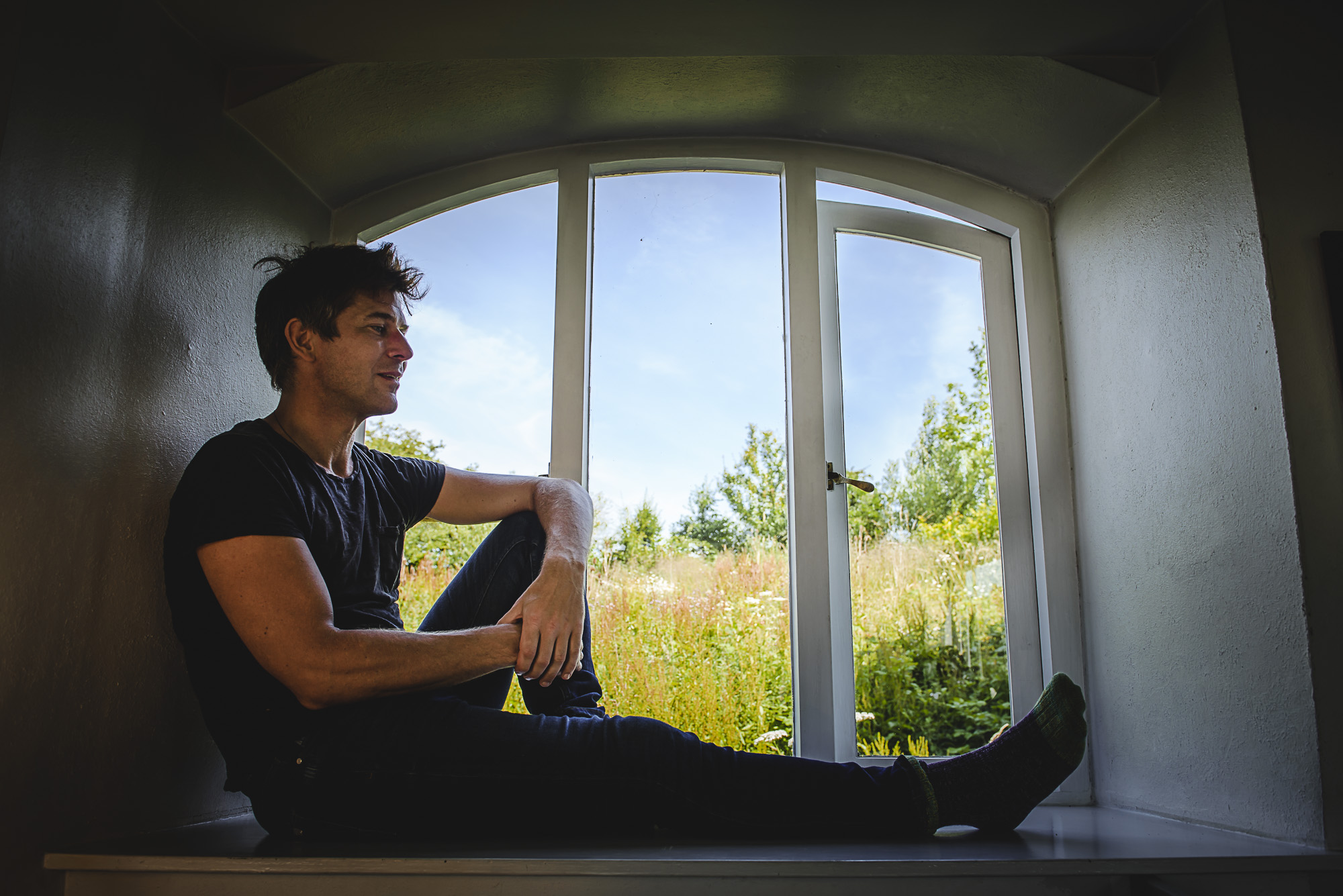 Tom Lawton sitting in a window looking outside